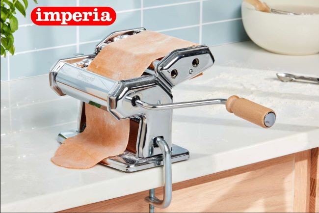 Imperia Titania heavy-duty pasta maker on a kitchen counter creating fresh pasta sheets.